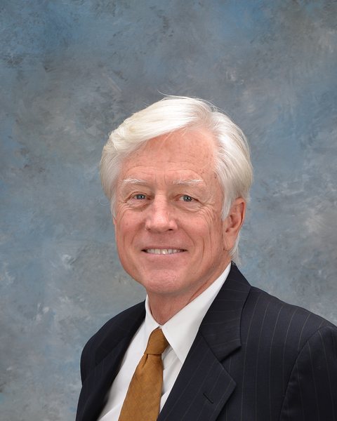 James Owen Cunningham, an older man with white hair, in a dark
                    pinstriped suit and gold tie.
